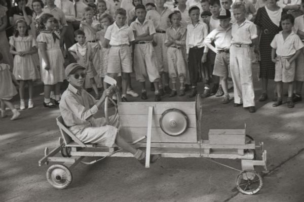 Roger Gabbei, age 12, competed in the Madison soap box derby held on Gorham Street. He carried a spare wheel in case of a crackup. Roger won the class B title. He lived at 1009 Lake Court.