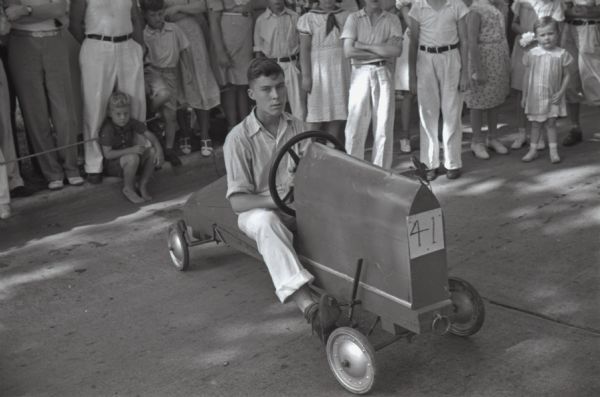 Fred Raemisch, 16, of 2234 E. Johnson Street, sitting in his championship soap box derby car, #41. This was the first official soap box derby held in Madison. Fred won a wristwatch.