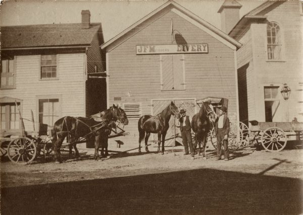 Men, wagons and horses in front of J.F. Meisser's Livery stable.
