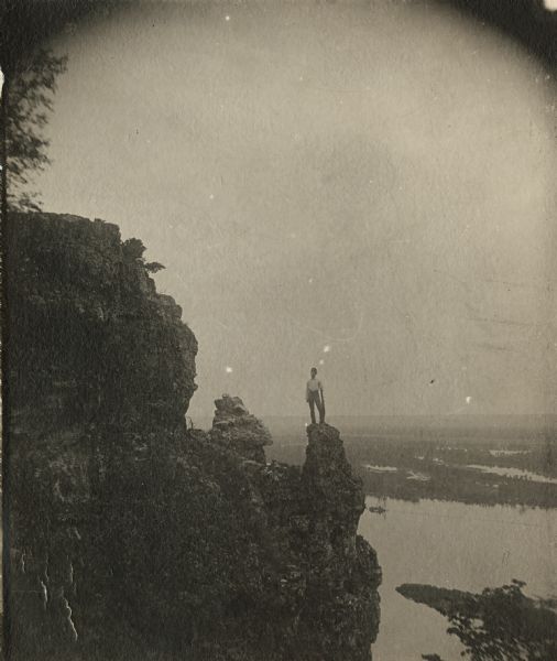Man standing on bluff with Mississippi River far below in the background.