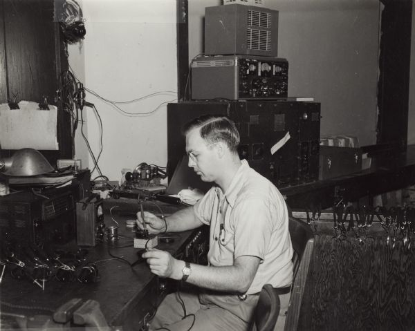 A man testing telegraph equipment at the U.S. Naval Training School (Radio).