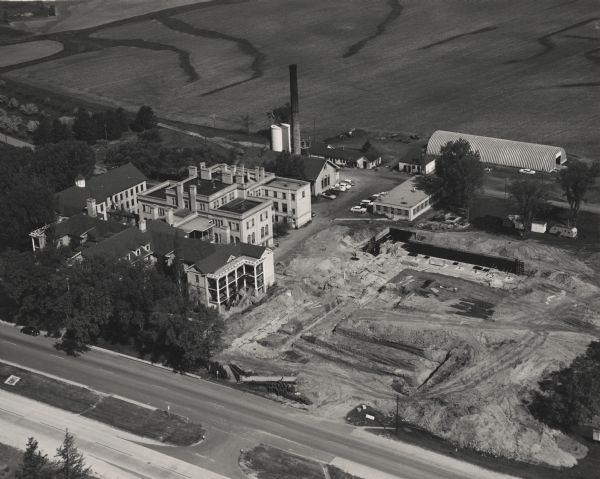 Aerial view of the Dane County Hospital, looking north. Excavating for a more modern east wing that was finished in 1960 can be seen.
It had been called the Dane County Asylum for the Criminally Insane. In 1880 it became a part of the county hospital system, which was set up to provide longer term care to people who were discharged from the state hospital system.