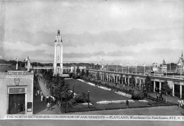 Elevated view of the north section of the Colonnade of Amusements at Playland, part of the Westchester Co. Park System.  The amusement park  features a large garden and a tower surrounded by the colonnade.