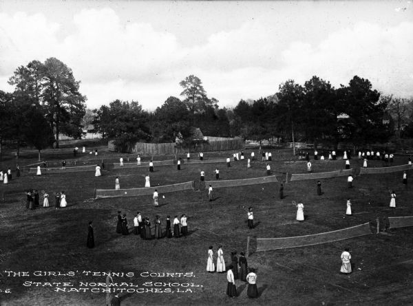 Elevated view of girls playing tennis on the lawn at the State Normal School.