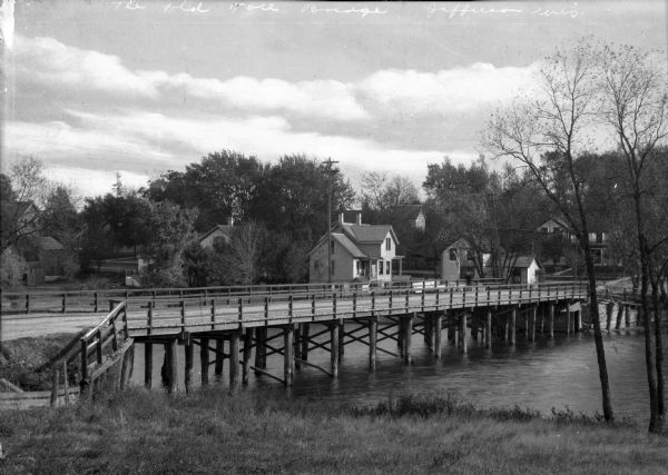 View of the Old Toll Bridge with buildings standing on the opposite shore.