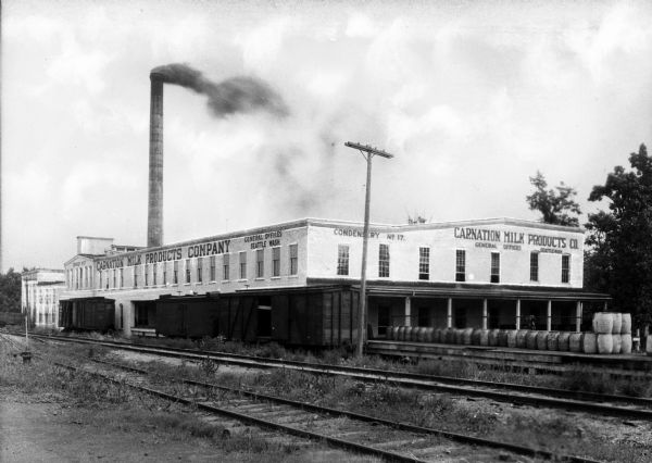 Exterior view of the Carnation Milk Products Company plant as seen from across railroad tracks.