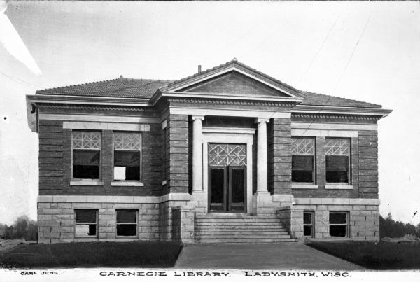Exterior view of Carnegie Library.  The brick building features stairs leading to the entrance, columns, and rectangular windows.