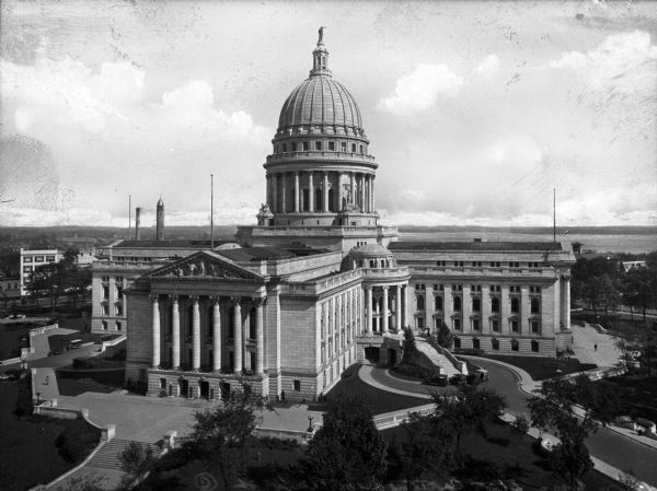 Elevated view of the state Capitol building looking west.  The building features columns, a dome topped by the statue Wisconsin, and multiple windows.
