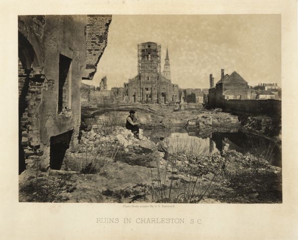 The ruins of Charleston after General Sherman's men burned the town near the end of the Civil War. A man, smoking a pipe, and a boy sit on the shoreline of a river near ruins. Across the water is a church building with scaffolding.<br>Plate 60</br>