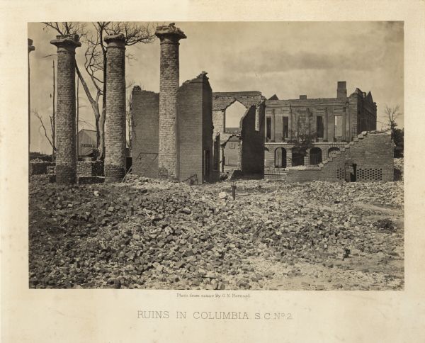 The ruins of Columbia after Sherman passed through, with damaged buildings, free-standing columns, and a pile of rubble.<br>Plate 55</br>