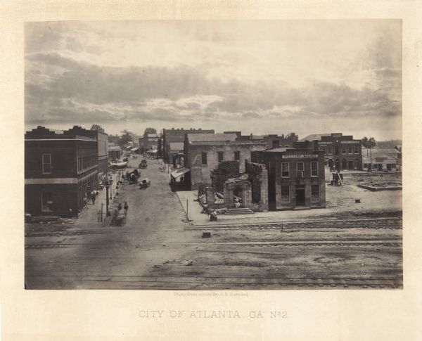 Elevated view of commercial area of the city, taken after General Sherman marched through. Most of the buildings appear to be intact,  but one of the buildings in the foreground is badly damaged.<br>Plate 46</br>