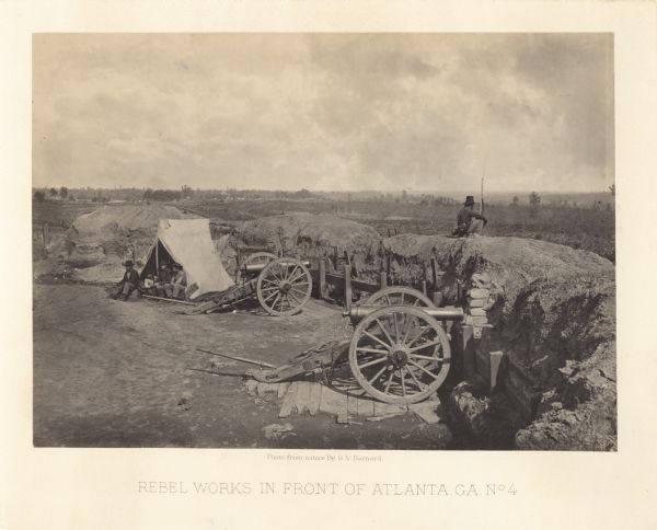 One of the Confederate defenses surrounding the city. This view is of the inside of the earthworks which includes two cannons. A Union soldier sits as a lookout on top of the earthworks, while more soldiers sit in front of a tent.<br>Plate 42</br>