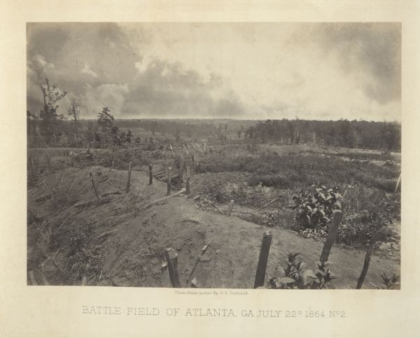 An empty battlefield with posts sticking out from an earthworks in the foreground.<br>Plate 37</br>