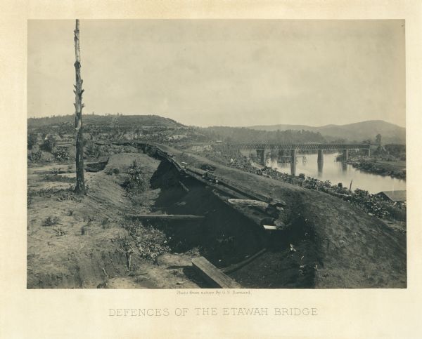 View along earthworks overlooking the Etawah River and a railroad bridge. A tree stripped of branches and bark is on the left.<br>Plate 23</br>