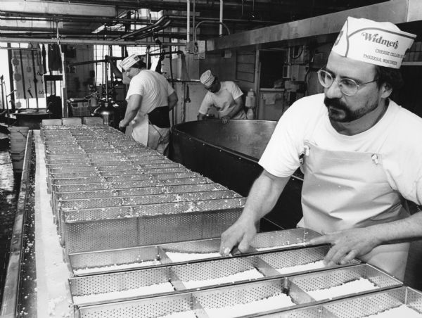 After the curds are leveled off in each form, they are turned so that each side of the Brick is pressed. During the course of the day, each form is turned three times to insure proper pressing.