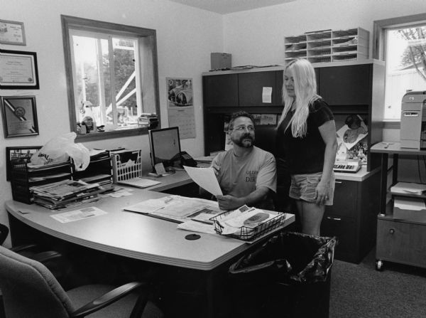CEO Joe Widmer and Office Manager, Kristine Miescke, go over reports in their office. Widmer's ships cheese to every state in the union.