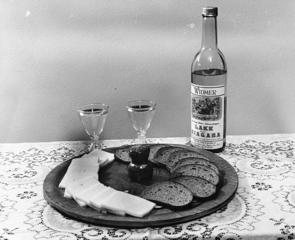 A cheese plate with slices of Brick Cheese, from Widmer's Cheese Cellars, paired with dark bread and a local wine.