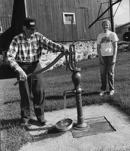 LeRoy Priesgen proves that this old pump still is capable of pumping water.
