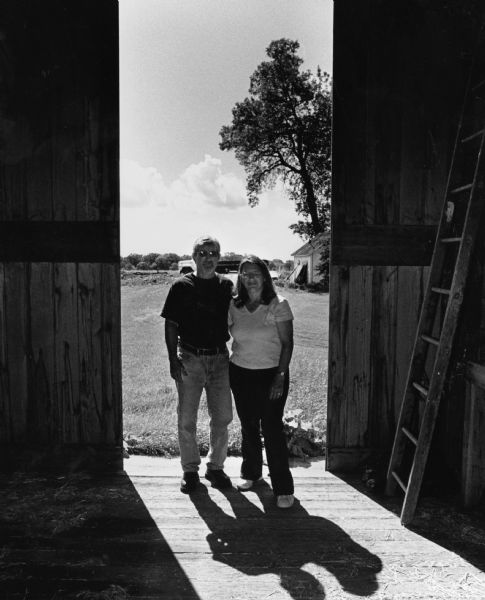 Ron and Sandy Schmitt stand in the doorway of their barn.