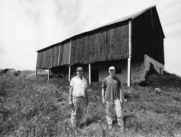 This barn, at W2208 Hwy AY (Section 31), stands isolated in a field between the farms of brothers Lloyd and Loren Giese. Lloyd Giese and his son, Andy, are shown.