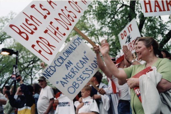 Protesters at Bush-Cheney rally. A sign reads: "Neo-colonialism - an "American" obsession.