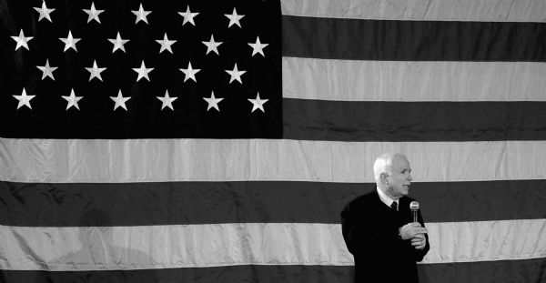 John McCain speaking, with an enormous American flag in the background.