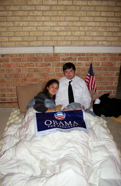 A couple of Obama supporters in a makeshift bed across from John McCain rally line.