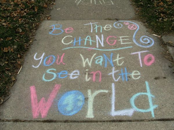 Gandhi quotation in sidewalk chalk. Reads: "Be the change you want to see in the world."