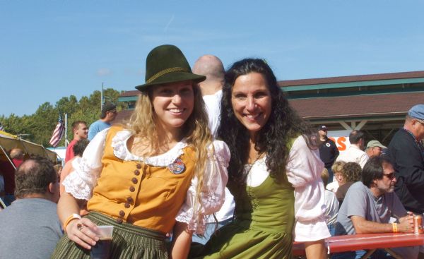 Two women (Frauleins) in costume posing for a picture at Oktoberfest.