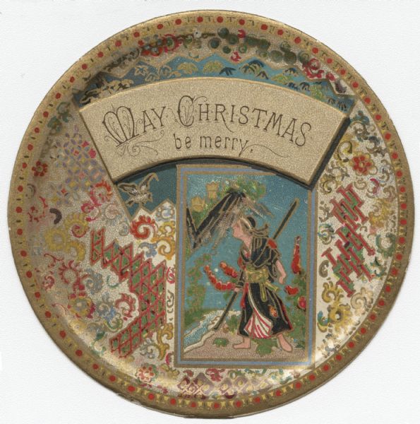 Round, die cut holiday card, with an ornate design on a metallic finish as the background. A rectangular framed image depicting a man walking with a staff near a mountain is under text on a gold background that reads: "May Christmas be merry." Chromolithograph. Image is embossed.