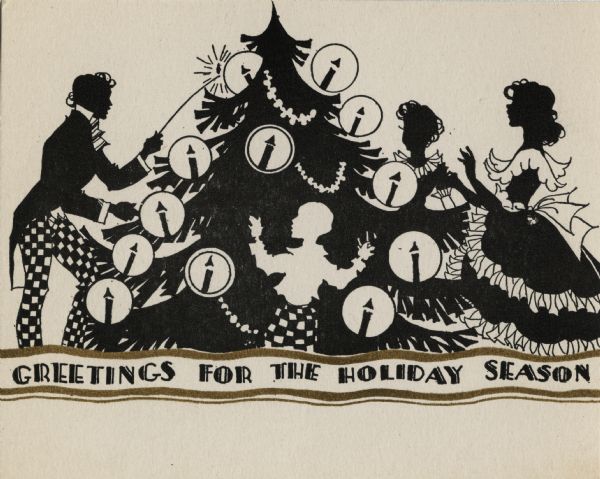 Holiday card with a silhouette image of a family gathered around their Christmas tree. The father is lighting the candles. The text "Greetings For The Holiday Season" appears below. Letterpress, black and metallic gold ink.