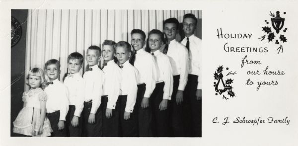Photographic holiday card of the C.J. Schroepfer family. All the boys are wearing white shirts, dark pants and bow ties or neckties. The little girl is wearing a frilly dress. Drapes are in the background. On the right is the text: "Holiday Greetings from our house to yours, C.J. Schroepfer family," with holly and door knocker illustrations.