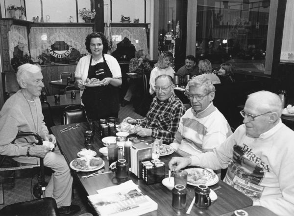 "At Jo's Corner Restaurant, Cod or Clams are $4.50. For some unknown reason, our waitress, Tammy Beekman did not charge us for a sumptuous dessert, even though she had been told of the oversight." From left to right; Ralph Widmer, Tammy Beekman, Rudy Heinecke, Ralph "Buddy" Ruecker, and John Bodden.