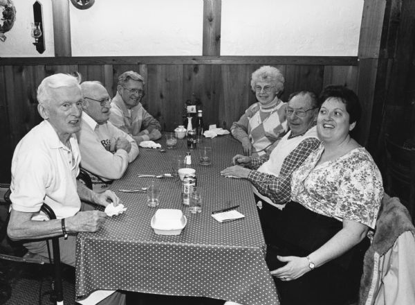 "Our waitress, Laurie Kuehl, sits down and jokes with us at the Mosey on Inn. Laurie informs us that her brother is the proprietor and her mother helps out in the kitchen. A perch dinner is $8.95." From left to right; Ralph Widmer, John Bodden, Ralph "Buddy" Ruecker, Shirley Widmer, Rudy Heinecke, and Laurie Kuehl.