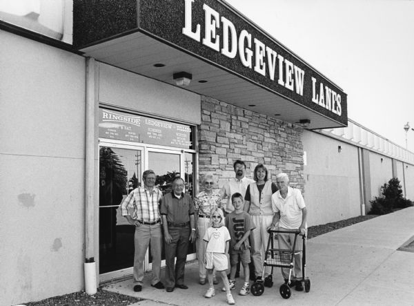 "Our group is joined by Kay, Larry, Parker & Carly Hren at Ledgeview Lanes located at 170 Prairie Road, Fond du Lac, WI." From left to right; Ralph "Buddy" Ruecker, Rudy Heinecke, Shirley Widmer, Carly Hren (lower row), Parker Hren (lower row), Larry Hren, Kay Hren, and Ralph Widmer.