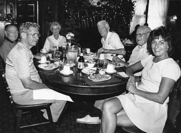 "At Timmer's on big Cedar Lake, our likable waitress, Julie Buck, sits down and chats with us." Pictured (clockwise around the table, starting on the left); Ralph "Buddy" Ruecker, Rudy Heinecke, Shirley Widmer, Ralph Widmer, John Bodden, and Julie Buck.