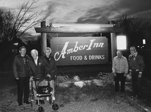 "The Amber Inn is in Slinger on Highway 60, about a mile west of the intersection with Highway 175." From left to right; Ralph "Buddy" Ruecker, Ralph Widmer, Shirley Widmer, Rudy Heinecke, and John Bodden.
