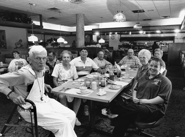 "Sarah Jaeger, is our waitress at the Lion's Family Restaurant in Fond du Lac." Pictured (clockwise, starting from the left): Ralph Widmer, Ruth Kern, Orville Kern, Rudy Heinecke, John Bodden, Ralph "Buddy" Ruecker, Shirley Widmer, and Sarah Jaeger.