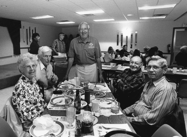 "At the Knights of Columbus in West Bend, Cy Wietor, who supervises a group of waiters, stops to chat with us at our table." From left to right; Shirley Widmer, Ralph Widmer, Cy Wietor, Rudy Heinecke, and Ralph "Buddy" Ruecker.