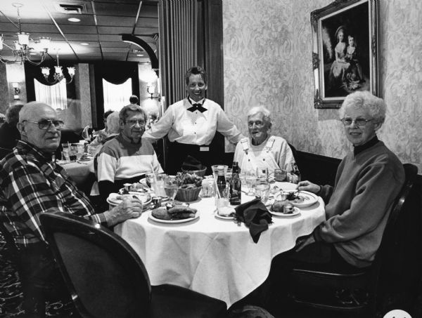 "Deb, our waitress, posed with us at The Port Hotel, in Port Washington, WI." From left to right; John Bodden, Ralph "Buddy" Ruecker, Deb, Ralph Widmer, and Shirley Widmer.