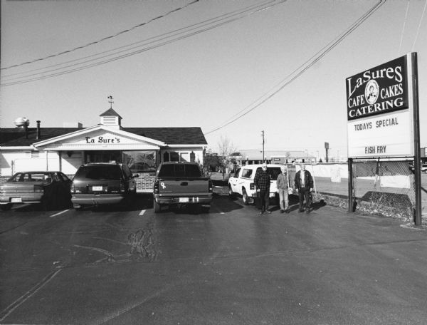 The fish fry group outside of La Sure's. The signboard advertises today's special, fish fry.