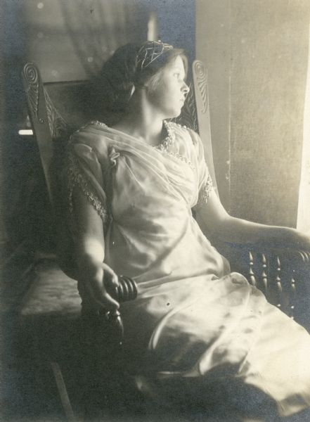 Leonore Judkins, later Mrs. Forest Middleton, seated in a chair. She is wearing her hair in a bun and wears a headband.