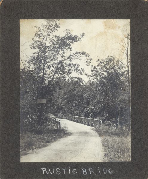 The rustic bridge on Lake Mendota Drive, over a ravine in Shorewood Hills. The sign on the left reads: "$5 FINE, For riding or driving over this bridge faster than a walk."