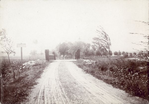 The rustic iron bridge on University Drive. The sign on the left advertises a $25.00 Reward. Lake Mendota is visible on the right.