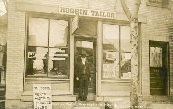 Captain William Hogbin stands on the steps of his tailor shop at 414 West Gilman Street. Captain Hogbin was born in England and trained as a tailor there. He immigrated to the United States with his parents and served in the Civil War in Company F, Eighty-eighth Illinois Volunteer Infantry. He was active in the Lucius Fairchild Post of the G.A.R. and had a tailor shop in Madison for many years. He is wearing his G.A.R. medal on his vest.