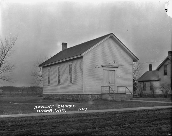 Exterior view of the Advent Church, featuring the church building situated next to a dwelling on the right.