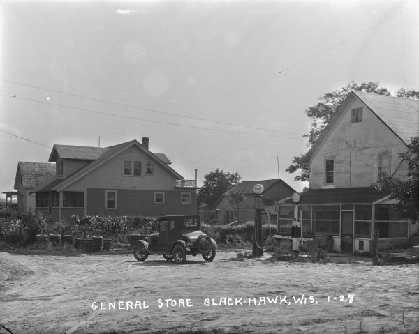A general store and gas station with a car parked in front.
