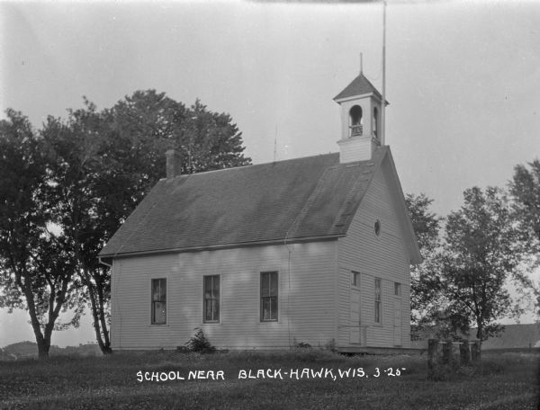 Exterior view of a school with  a gable roof with bell steeple.