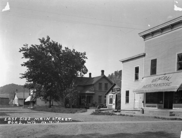Exterior of the "General Merchandise - A.C. Hanold groceries" and the "garage and auto livery."