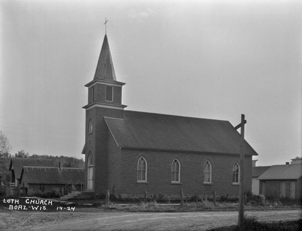 Exterior of Lutheran church. The building features a steeple with a cross and arched windows.
